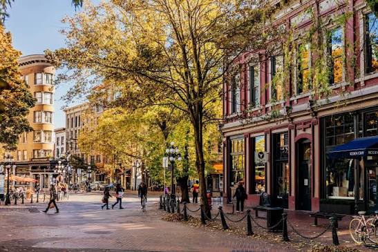 Autumn streetscape in downtown Maple, Ontario with historic brick storefronts and yellow foliage.